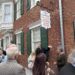 Crowd of people gathered outside a brick building with a hanging sign reading 'Cockey's Library of Carroll County History' outside the Historical Society.