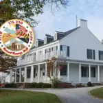 Large white historic house with a wraparound porch on a curved driveway, autumn trees, and an overlaid circular US 250 commemorative seal.