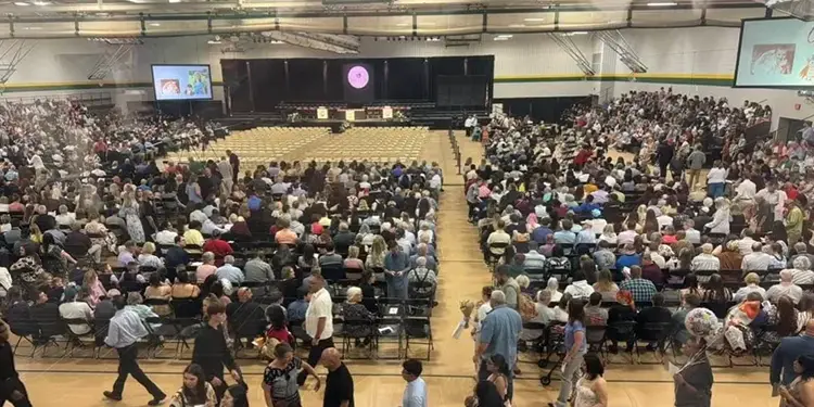 westminster-graduations - Carroll News | Carroll Publications | Carroll County, MD Large school gym packed with hundreds of attendees seated and facing a stage with screens on either side.