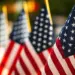 july4th-image-carroll - Carroll News | Carroll Publications | Carroll County, MD Rows of American flags on flagpoles, close-up foreground flag with others blurred in the background at a patriotic display